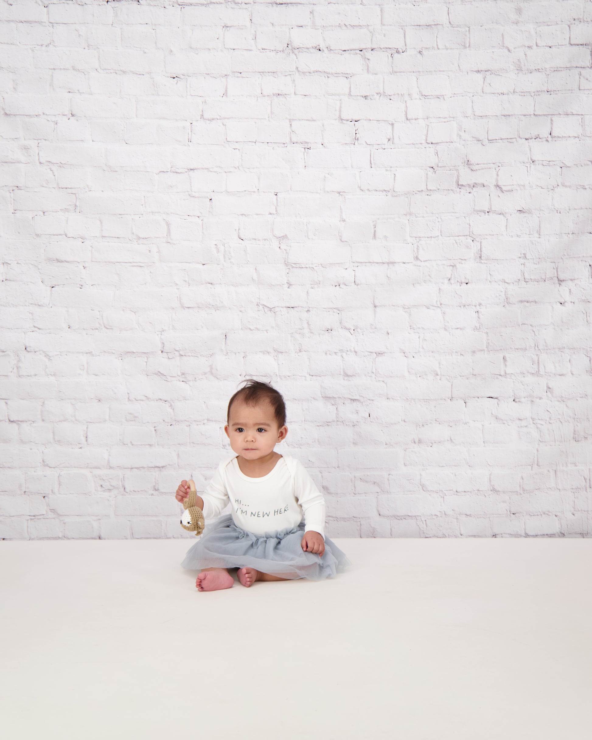 baby sat in slogan onesie and silver bloomer tutu